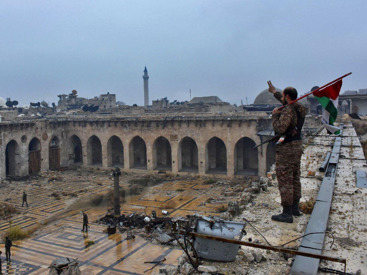 عکاس‌خانه: پرچمی که «مدافع حرم» بر خرابه‌های حلب برافراشت